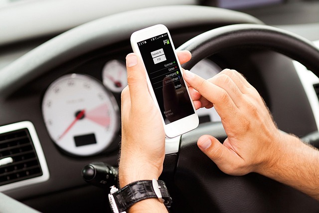 smartphone und zwei hände hinter dem lenkrad